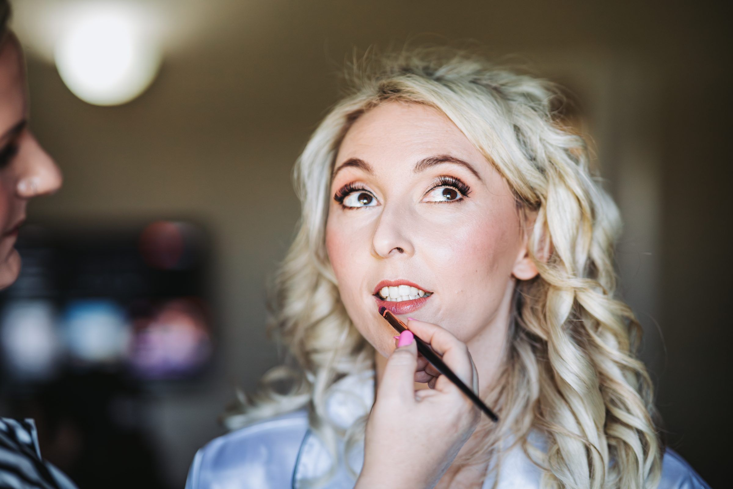 Bride having her lipstick applied before the ceremony