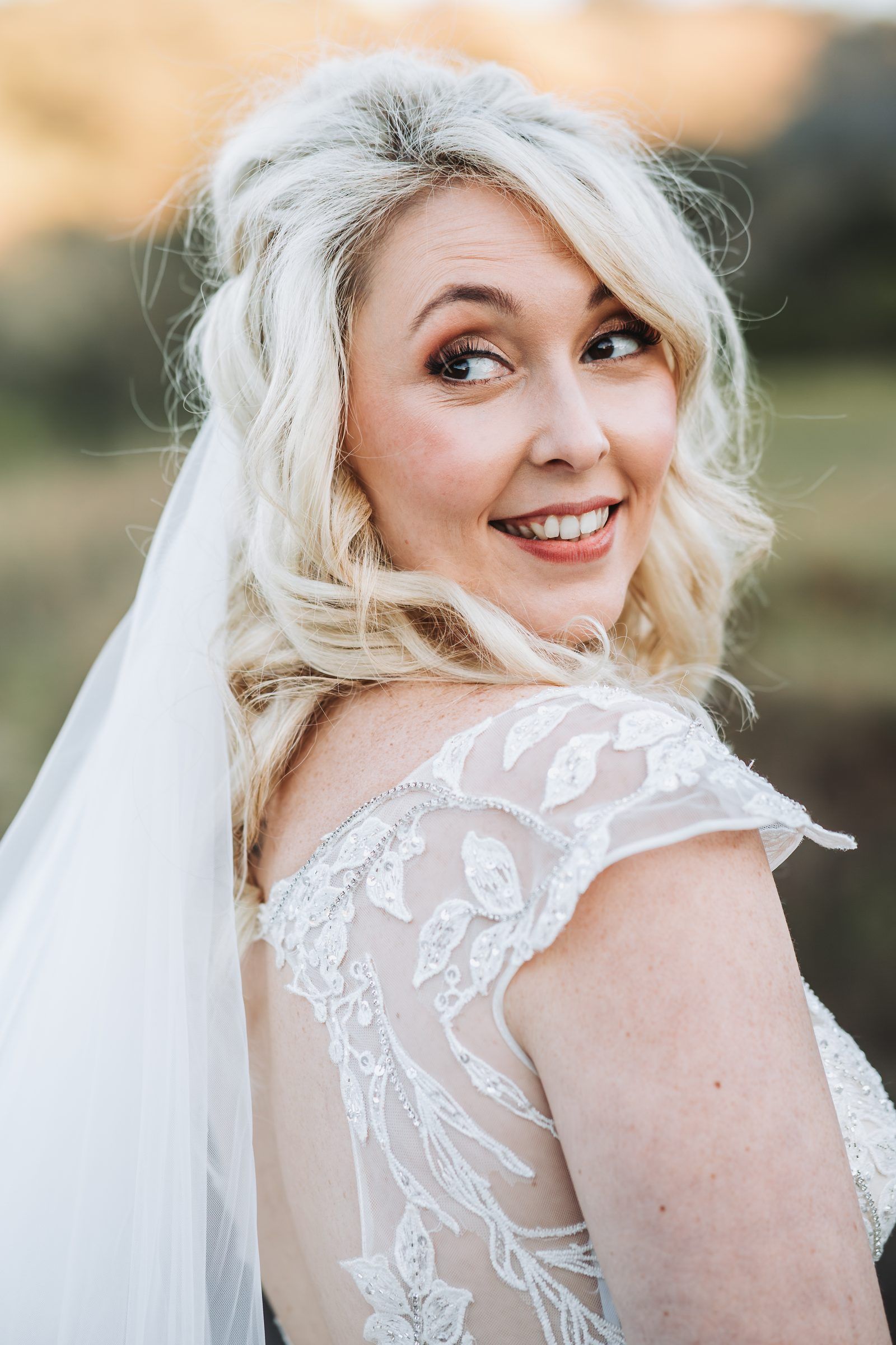 Bride in a lace-sleeved gown under her veil